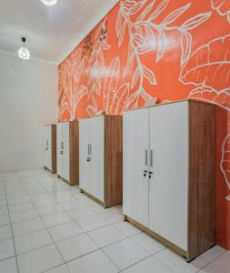 a row of lockers in a room with an orange wall at Snooze Ijen in Banyuwangi