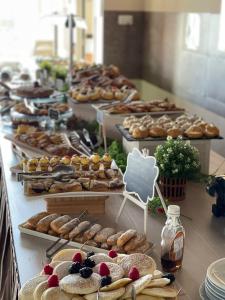 ein Buffet mit vielen verschiedenen Arten von Gebäck und Desserts in der Unterkunft Hotel Ideal Soleti Hotels in Rimini