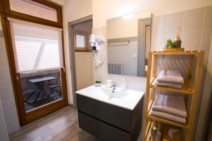 uma casa de banho com um lavatório e um espelho em Chambres Chez Laurence em Kaysersberg