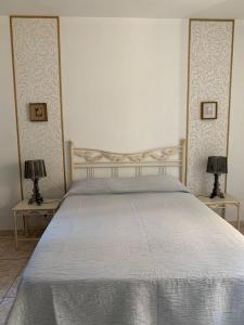 a bed in a bedroom with two lamps on tables at Sole e Mare in Galeria