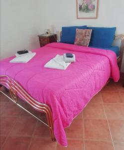 
a bed with a pink blanket and pillows on it at Antico Borgo di Torri in Sovicille
