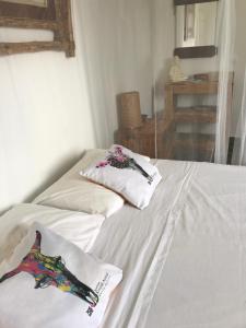 Duas camas num quarto com lençóis e almofadas brancos em LES ALOÈS By CREYOL ANIMAL em Grand-Bourg