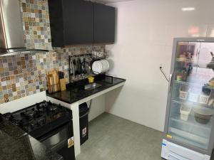 a kitchen with a stove top oven next to a refrigerator at Lila Limao Hostel in Abraão