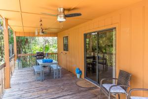 um alpendre com uma ventoinha de tecto, cadeiras e uma mesa em The Florida Keys Treehouse in Marathon, FL em Marathon