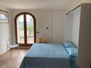 ein Schlafzimmer mit einem Bett, einem Stuhl und einem Fenster in der Unterkunft Attico Matine in Specchia
