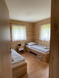 a room with two beds in a wooden cabin at Family Bungalow Glamping Laško in Laško