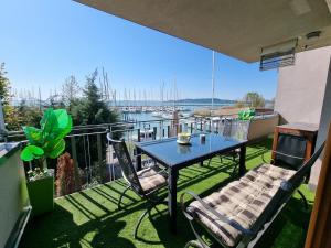 a table and chairs on a balcony with a view of a marina at Bilberry Apartman in Balatonfüred