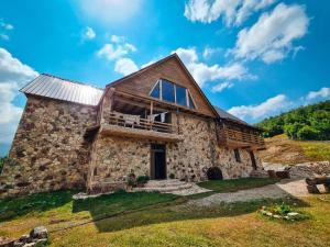 an old stone house with a balcony on a hill at Hotel Kelmendi in Lëpushë