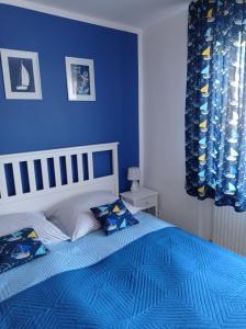a blue bedroom with a bed with blue walls at Szanta in Jastarnia