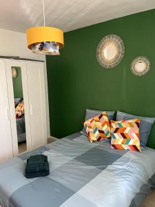 - une chambre verte avec un lit et un sac dans l'établissement APPARTEMENT LE ROUSSEAU METZ AVEC PARKING GRATUIT, à Metz