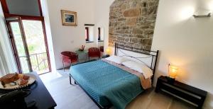 a bedroom with a bed and a stone wall at Arbanella in Corniglia