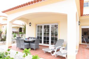 Un patio con una mesa y sillas en una casa. en Casa América, en Casal da Lagoa Seca