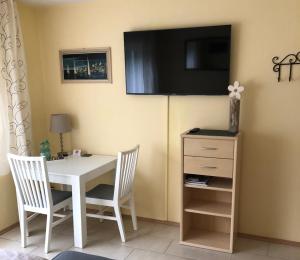 a table with two chairs and a television on the wall at Ferienwohnung Appartement in Rheinbrohl in Rheinbrohl