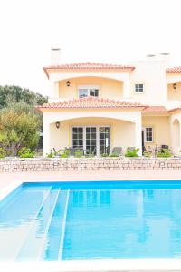 una villa con piscina frente a una casa en Casa América, en Casal da Lagoa Seca