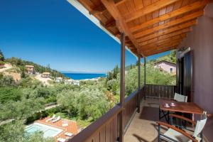 a balcony with a table and chairs and a view of the ocean at Evridiki's Villas in Agios Nikitas