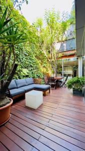 eine Terrasse mit einem Sofa, einem Tisch und Bäumen in der Unterkunft ArtlifeBCN Urban Oasis Apartment in Barcelona