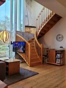 Una sala de estar con escalera y televisor. en Villa Lotta, en Åsa
