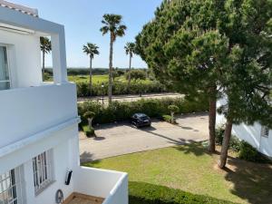 un coche aparcado en un estacionamiento junto a una casa en Apartamento Retama Golf, en Chiclana de la Frontera