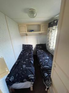 a small room with two beds in a caravan at Family 5 beds static caravan in Lincolnshire