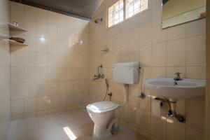 a bathroom with a toilet and a sink at Amritara Riverside Luxury Tents in Thattakād
