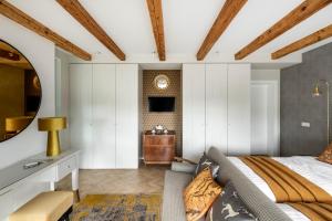 ein Schlafzimmer mit einem Bett und einem Spiegel in der Unterkunft Suite with private bathroom at three bedroom interwar Villa Grabyte with daily spaces to share by pine forest on the bank of the river- 8min by car from old town in Kaunas