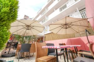 a patio with tables and chairs and umbrellas at Sakura Hotel Nippori in Tokyo