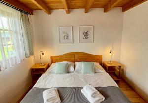 1 dormitorio con 1 cama con 2 toallas en Chata 107 Tatralandia Village en Liptovský Mikuláš