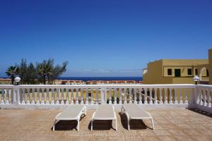 balkon z 2 krzesłami i białym płotem w obiekcie Caleta Paraiso Sea View 137 w mieście Costa de Antigua