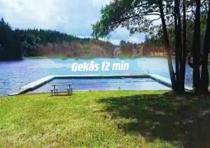 ÄlvseredLin's B&B的坐在湖边草上的长凳