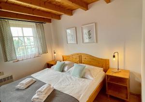 1 dormitorio con 1 cama con 2 toallas en Chata 107 Tatralandia Village, en Liptovský Mikuláš