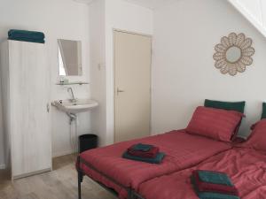 una camera con letto rosso e lavandino di Voorstraat-Straatzicht Boven a Dordrecht