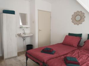 a bedroom with a red bed and a sink at Voorstraat-Straatzicht Boven in Dordrecht