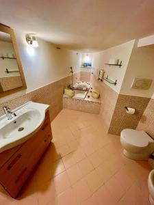 e bagno con lavandino, servizi igienici e vasca. di MARMORE HOUSE a Collestatte