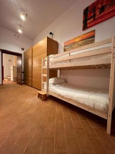 2 letti a castello in una camera con pavimento in legno di MARMORE HOUSE a Collestatte
