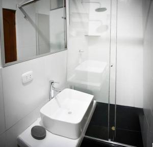 ein weißes Bad mit einem Waschbecken und einer Dusche in der Unterkunft Moderno y hermoso apartamento en Tarapoto con 3 Dormitorios, ideal para familias in Tarapoto