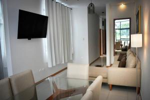 un soggiorno con divano e tavolo in vetro di Moderno y hermoso apartamento en Tarapoto con 3 Dormitorios, ideal para familias a Tarapoto