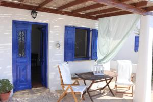 リプシにあるNiriedes Villasの青いドアとテーブルと椅子が備わる家