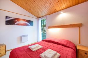 a bedroom with a red bed and a window at LE HAMEAU DES ETOILES in Fleurance