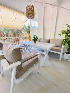 een woonkamer met een witte tafel en een bank bij Apartamento El Mentiro in Cabopino