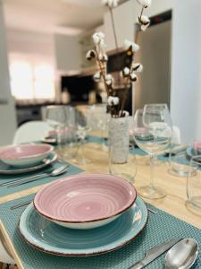 een tafel met borden en wijnglazen erop bij Apartamento El Mentiro in Cabopino