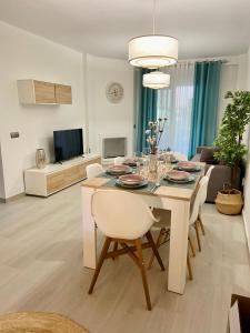 een woonkamer met een eettafel met stoelen bij Apartamento El Mentiro in Cabopino