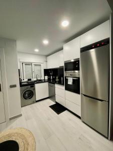 een keuken met een roestvrijstalen koelkast en een vaatwasser bij Apartamento El Mentiro in Cabopino
