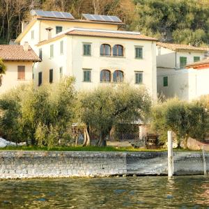 een groot gebouw naast een waterlichaam bij Sensole locanda contemporanea in Monte Isola