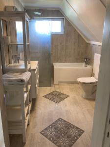 La salle de bains est pourvue d'un lavabo, de toilettes et d'une douche. dans l'établissement Bulls Haven Villa Kristiansand, à Kristiansand