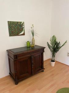 a wooden cabinet with two vases and two plants on it at Ferienwohnung im südsteirischen Weinland - Haus Birgit in Arnfels