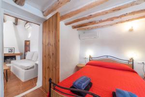 a bedroom with a red bed and a white chair at FINCA RELAX IBIZA STILE in Sant Josep de Sa Talaia