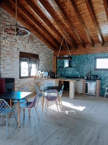 Habitación con mesas, sillas y pared de ladrillo. en Pura Agro Vida, en Galizano