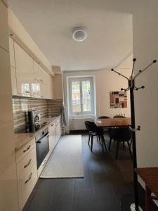 a kitchen with a table and a dining room at Appartement LUNA avec parking couvert privé in Le Locle