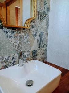 lavabo blanco en el baño con azulejos en la pared en Pura Agro Vida en Galizano