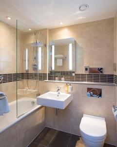 a bathroom with a sink and a toilet and a shower at Bush Hotel Farnham in Farnham